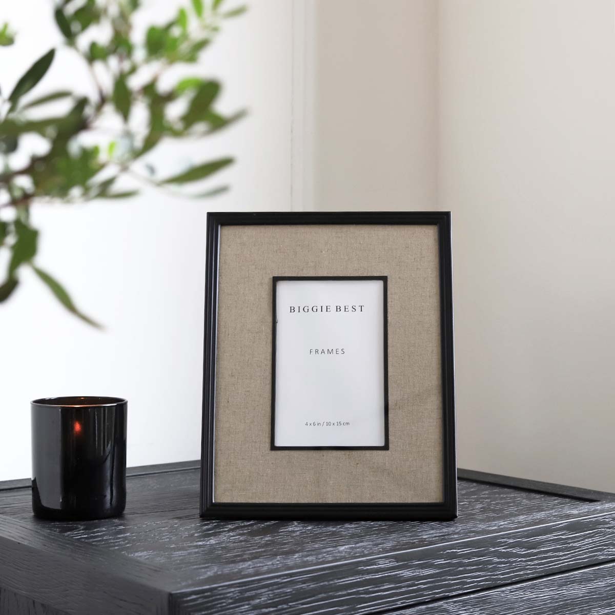 Two stacked book shaped storage boxes, with an artificial foiliage stem placed stylishly on top.